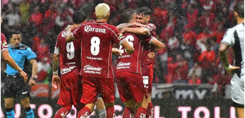 Jugadores de Toluca celebrando un gol en la lluvia