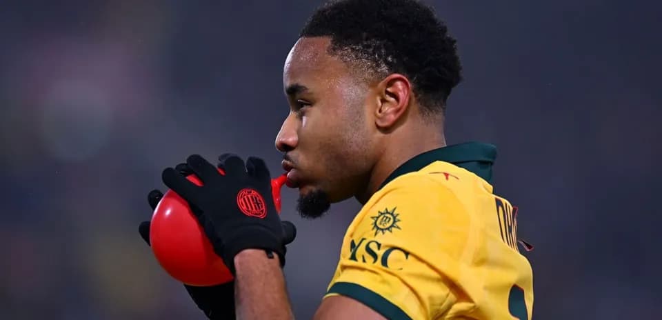 Jugador soplando un globo rojo durante el partido