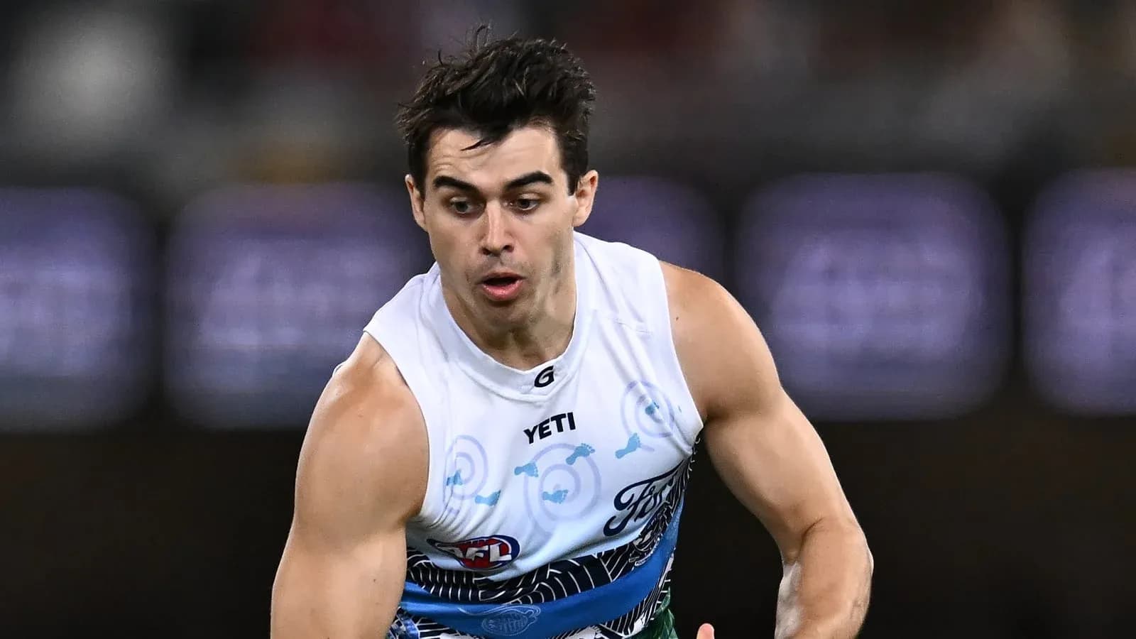 Jugador corriendo con balón durante partido de AFL