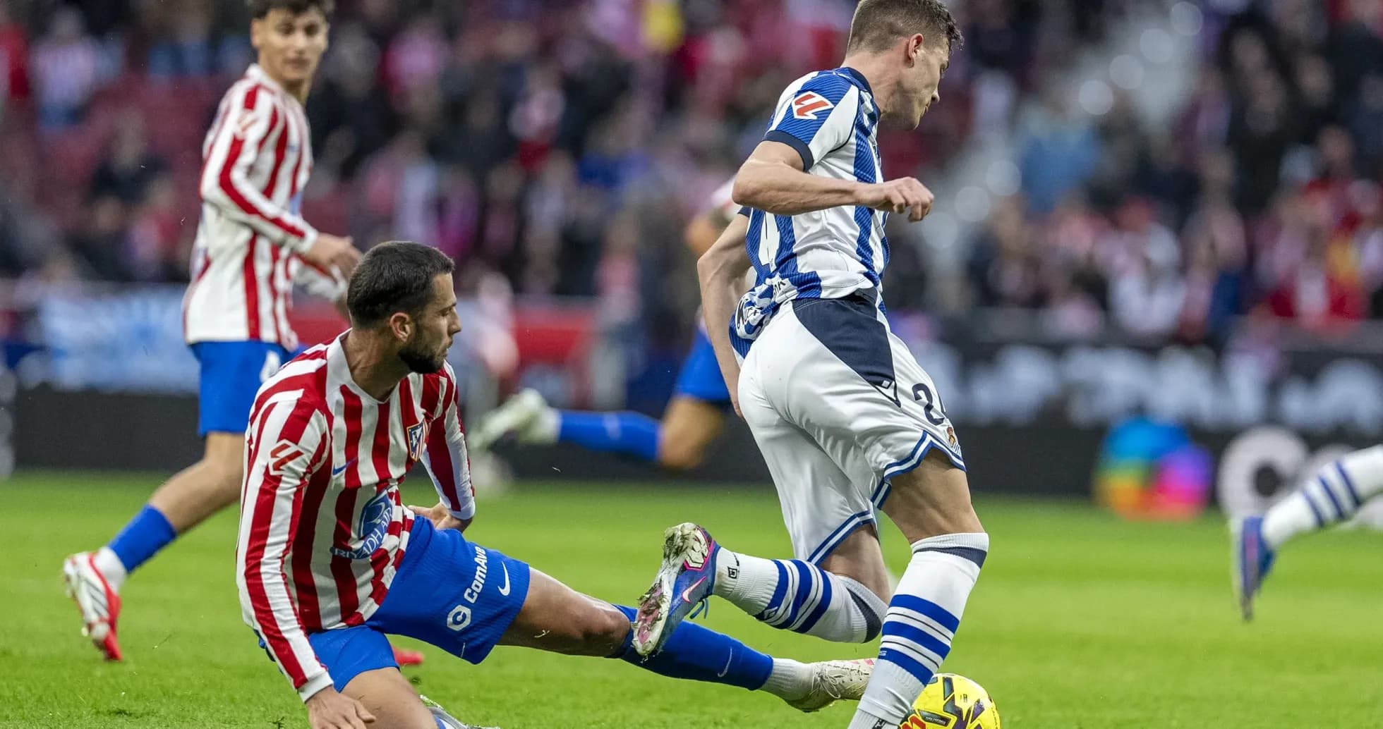 Un jugador de la Real Sociedad driblando a un rival