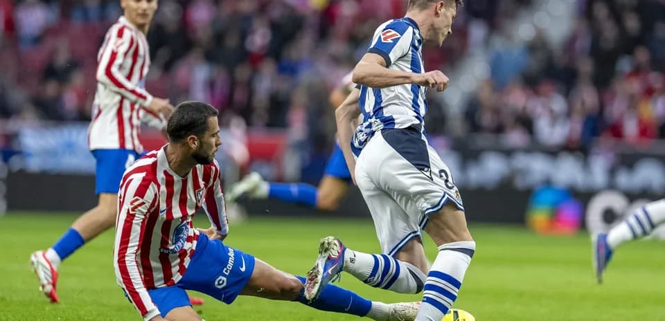 Un jugador de la Real Sociedad driblando a un rival