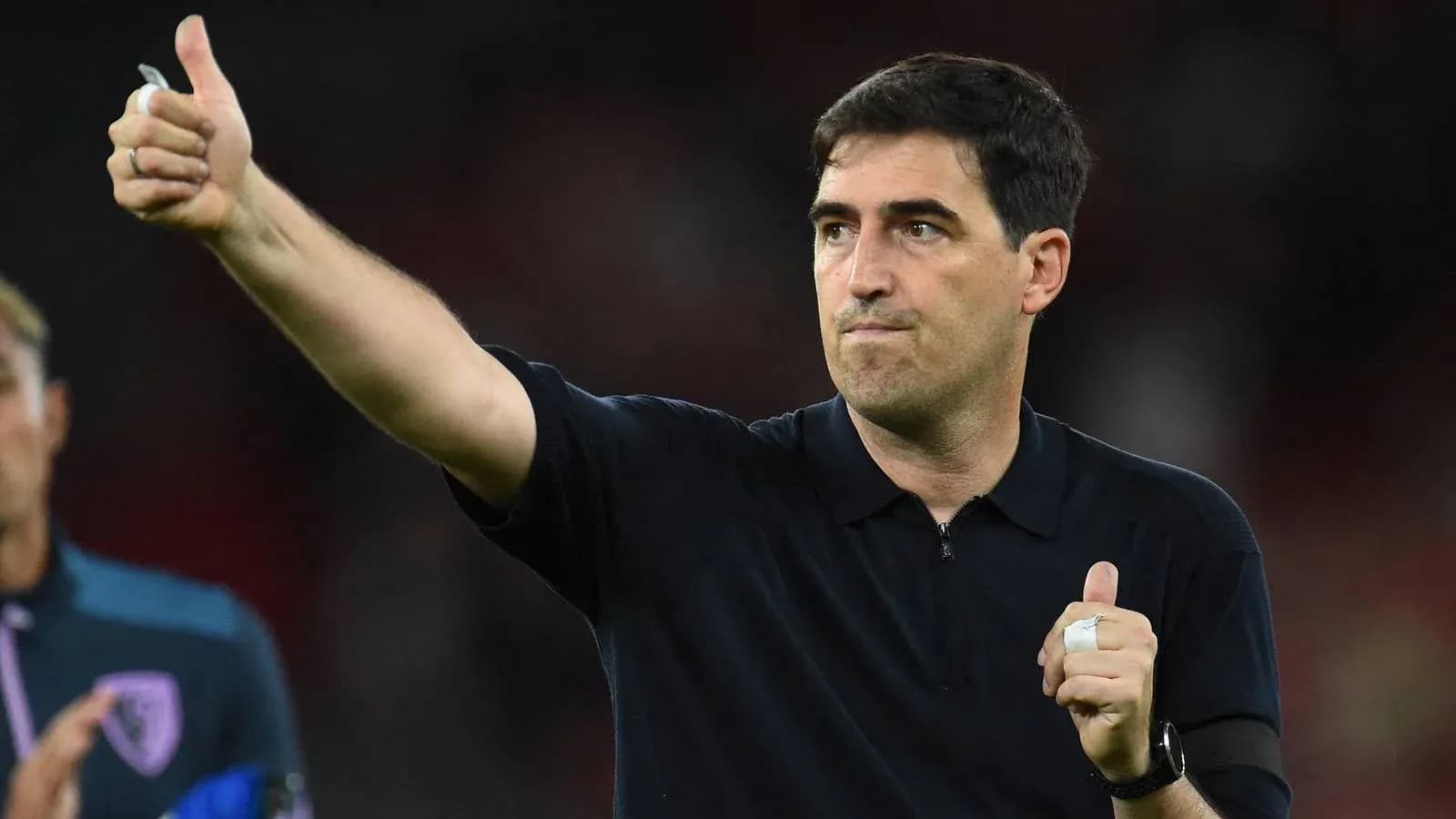 Entrenador dando señal de aprobación durante partido