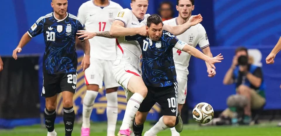 Lionel Messi regateando a un jugador inglés