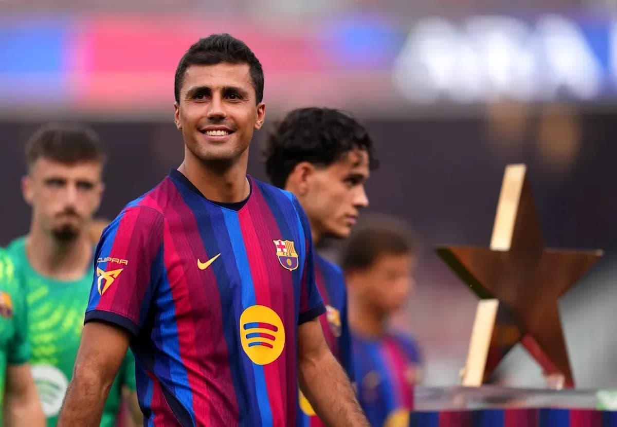 Jugador de Barcelona sonriendo junto a compañeros y trofeo