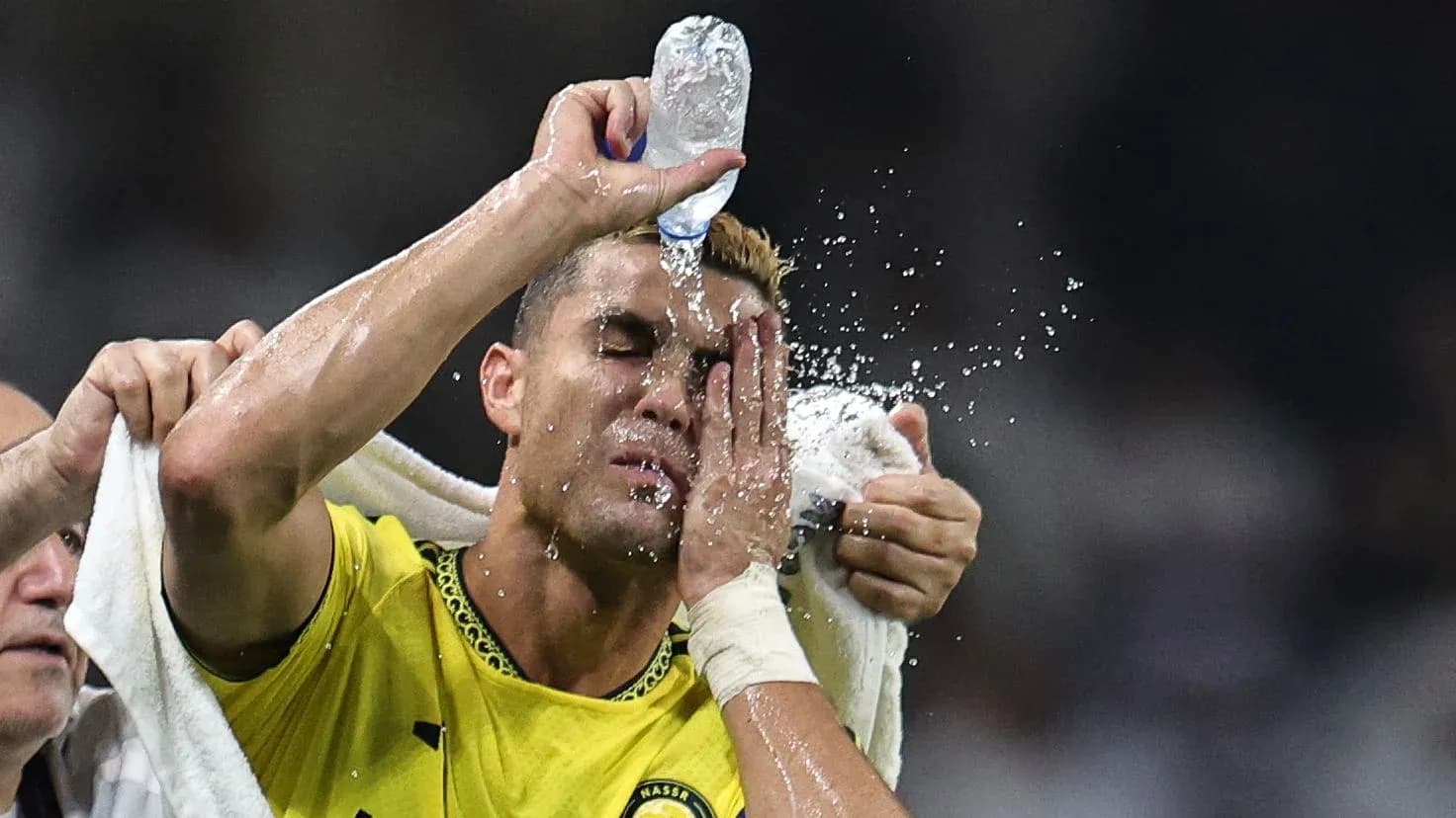 Jugador refrescándose con agua durante el partido