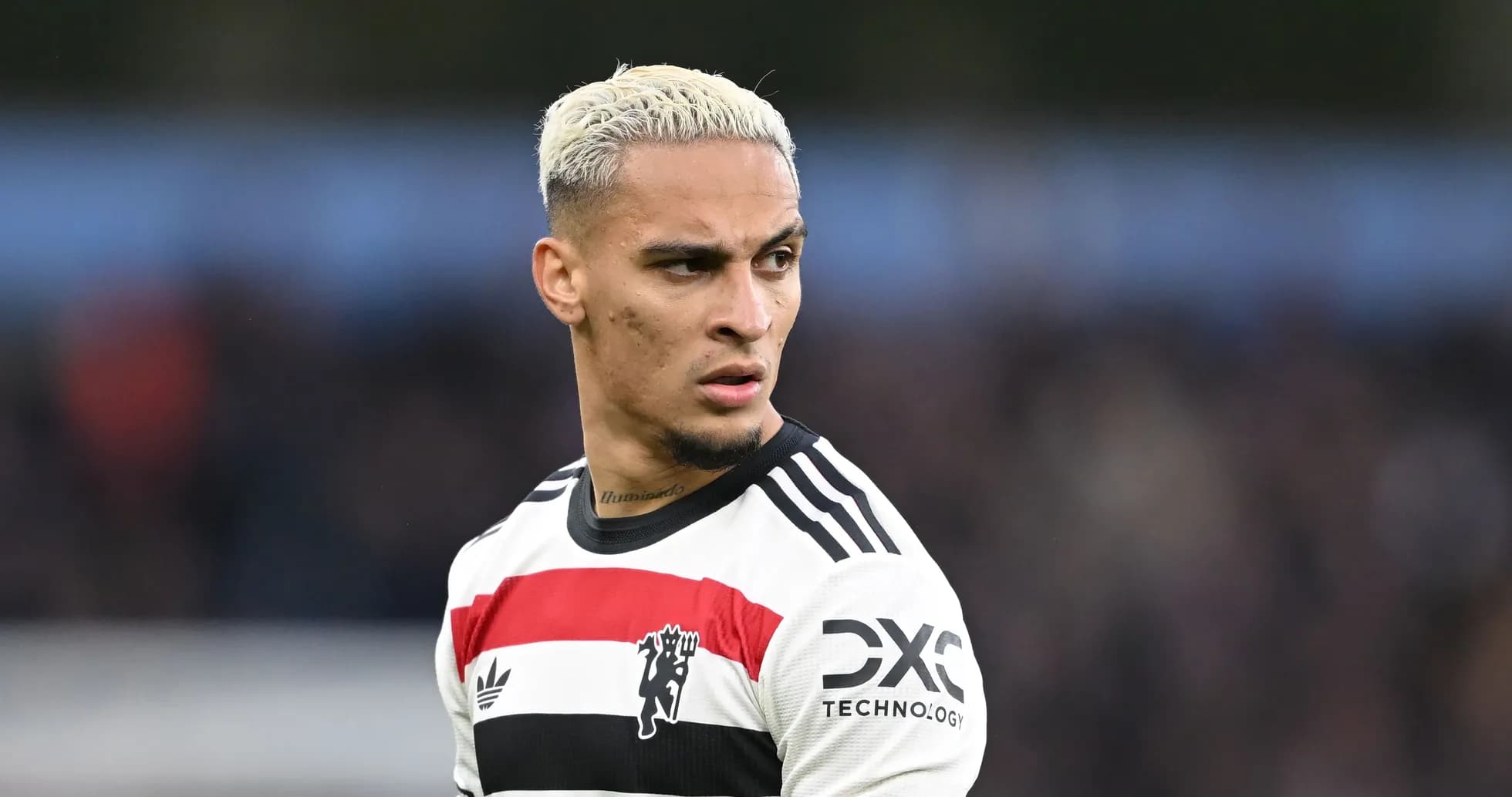Jugador de fútbol con camiseta blanca y negra en acción