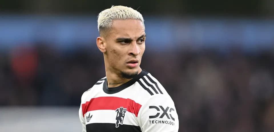 Jugador de fútbol con camiseta blanca y negra en acción