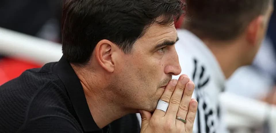 Entrenador observando el partido desde el banquillo