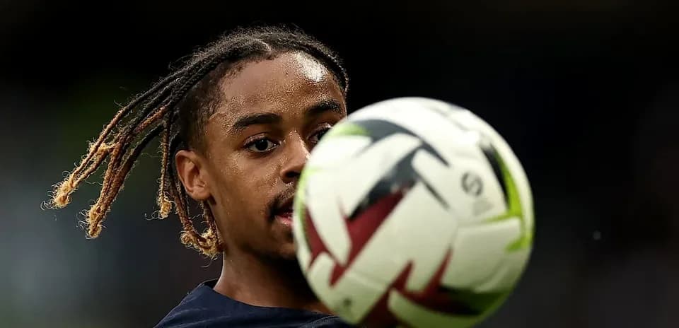 Jugador controlando un balón de fútbol en el campo