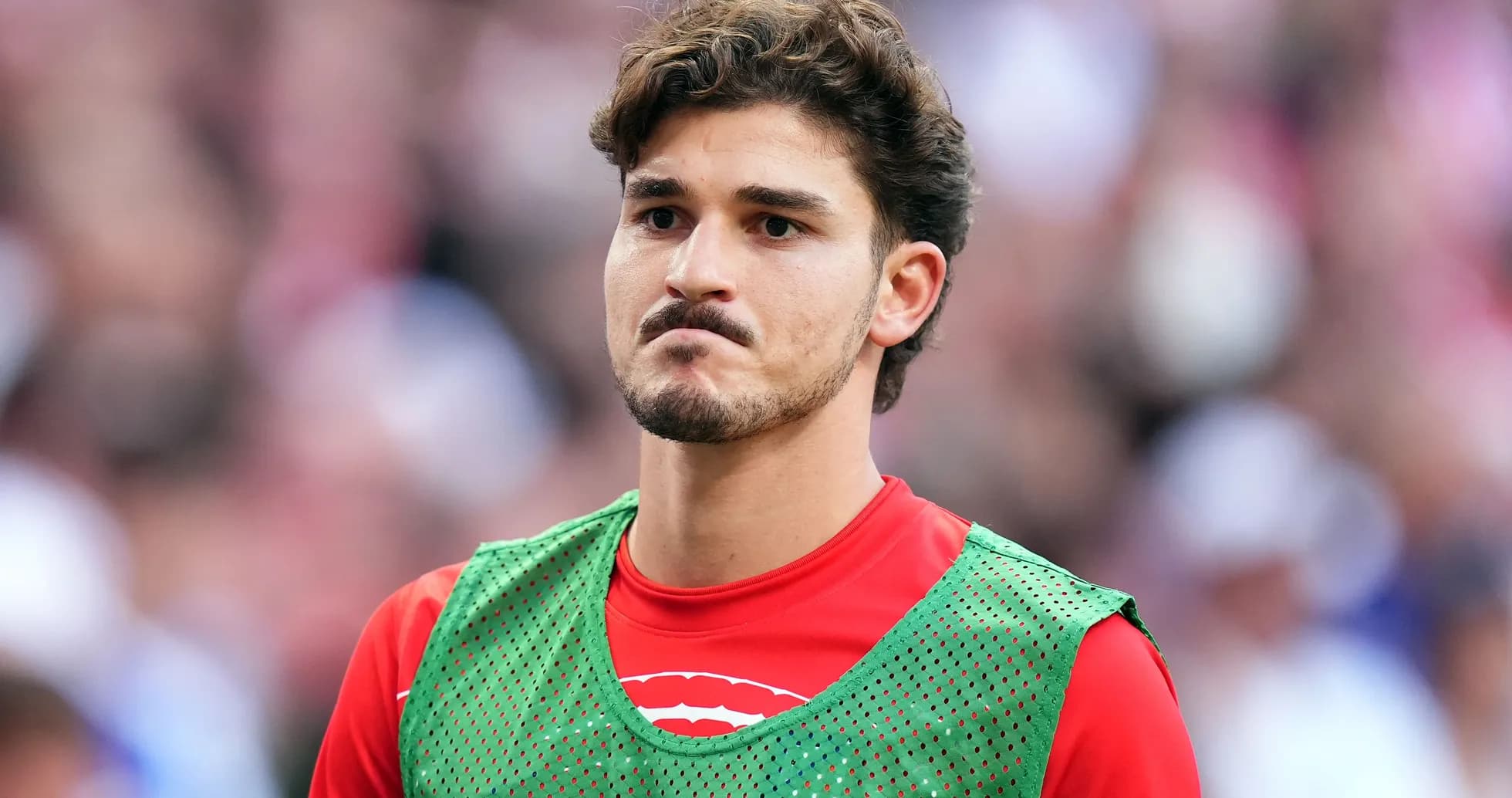 Jugador en la banca con chaleco de entrenamiento