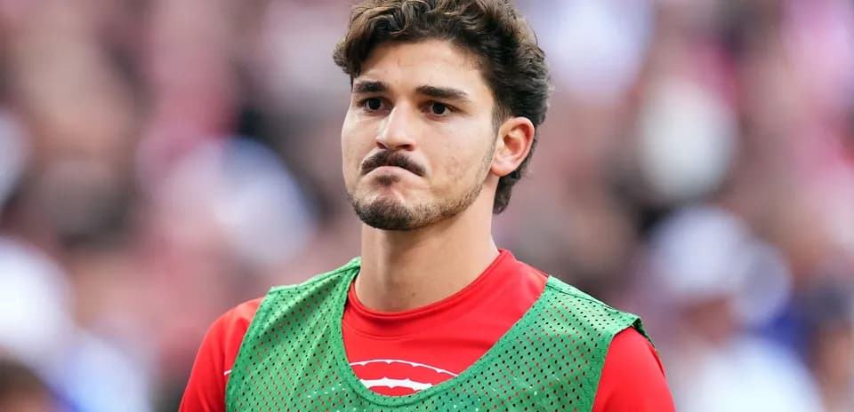 Jugador en la banca con chaleco de entrenamiento