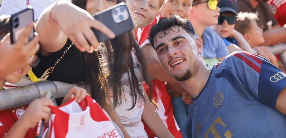 Jugador sonriendo con fans y firmando autógrafos