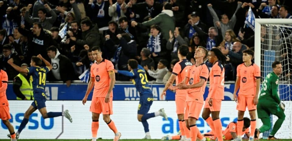 Jugadores de equipo en camiseta rosa tras gol rival