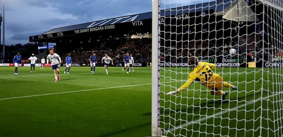 Jugador ejecutando un penalti mientras el portero se lanza