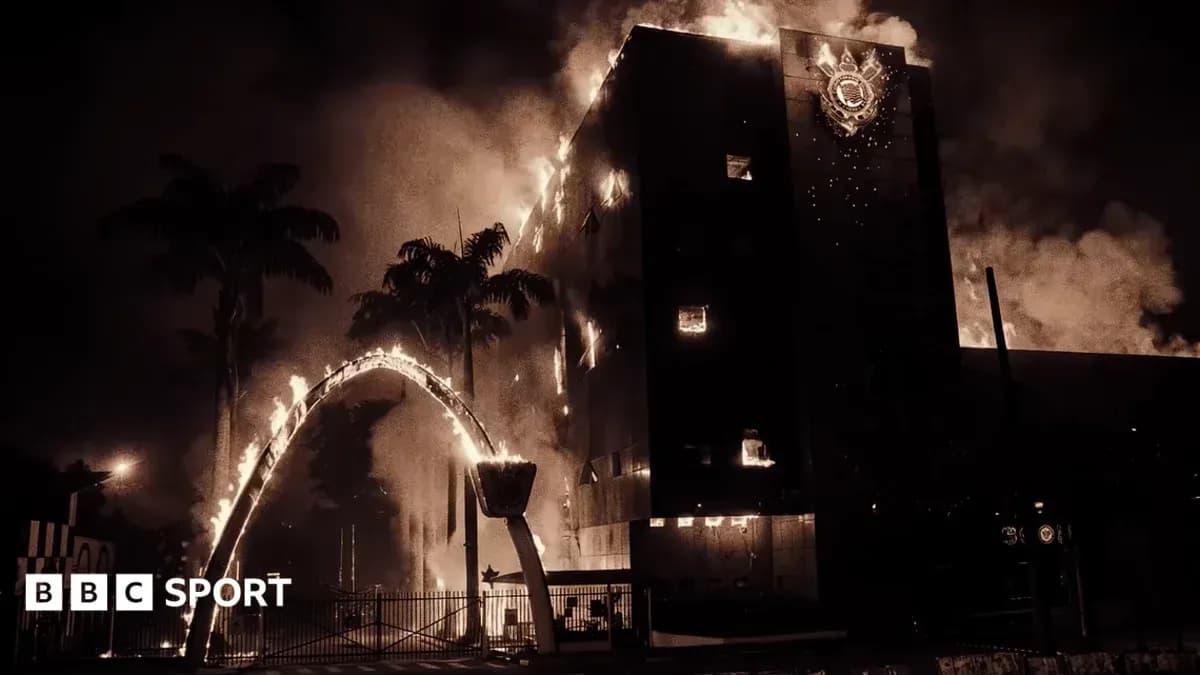 Edificio en llamas con humo y palmeras alrededor