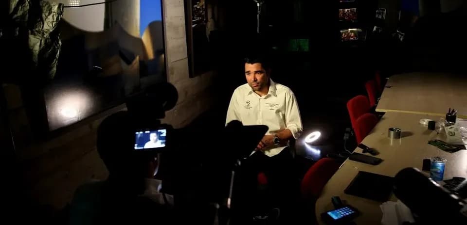 Entrevista en un estudio con mesa y sillas rojas