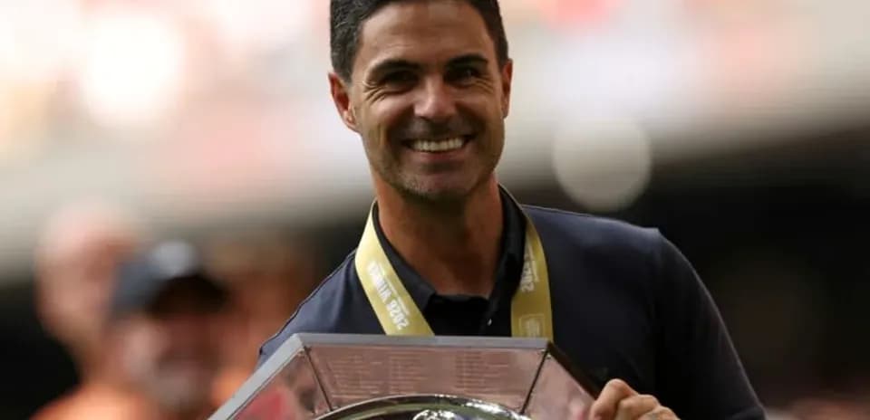 Entrenador sosteniendo trofeo en ceremonia de celebración