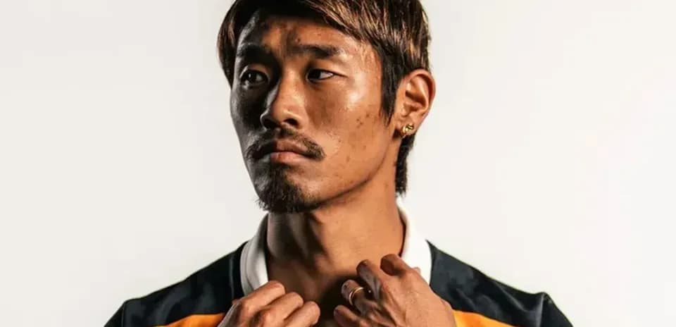 Jugador posando con camiseta deportiva y accesorios