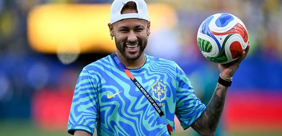 Neymar sosteniendo un balón de fútbol en el campo