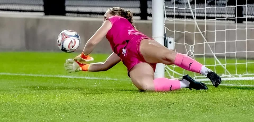 Portera atrapando el balón en la línea de gol