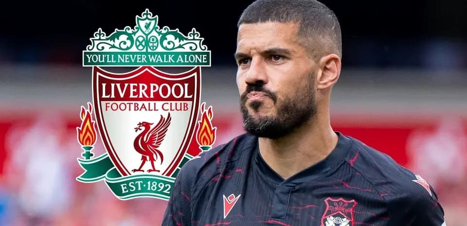 Jugador con camiseta negra frente al escudo de Liverpool