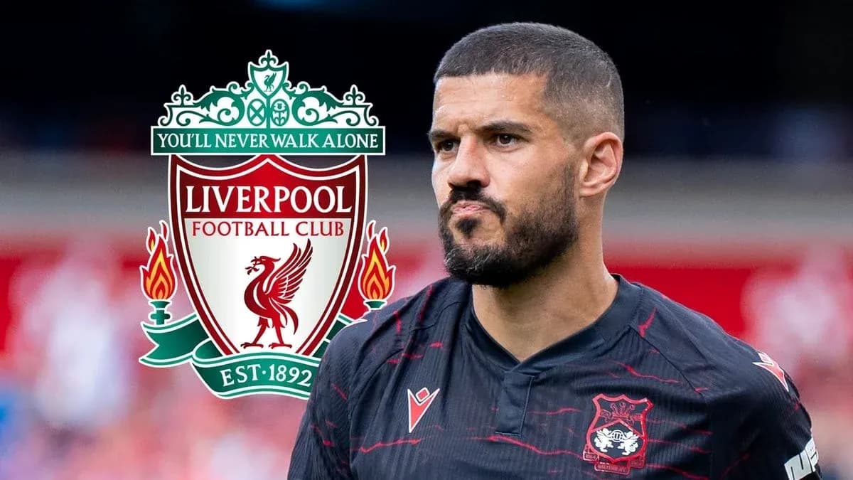 Jugador con camiseta negra frente al escudo de Liverpool