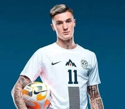 Jugador sosteniendo balón en uniforme de fútbol