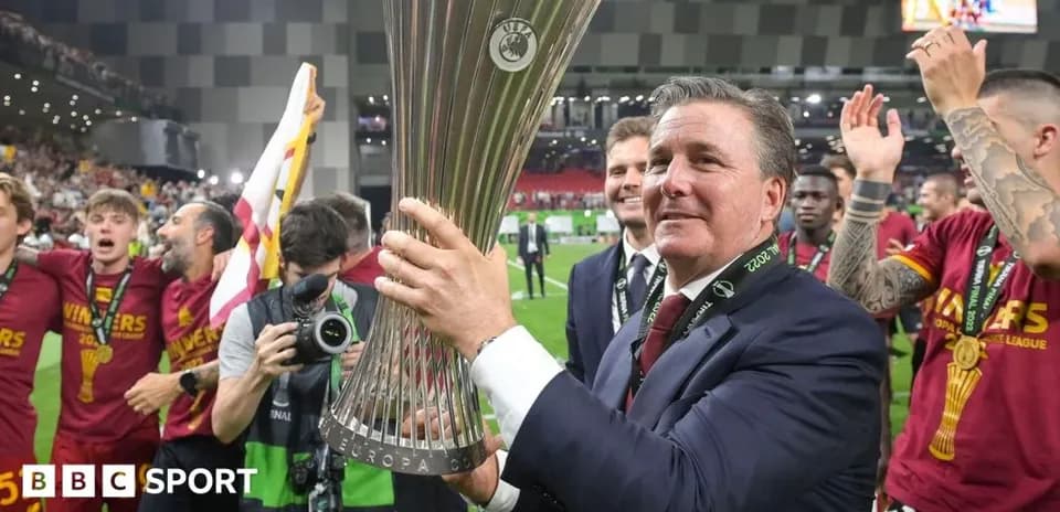 Entrenador celebrando con el trofeo de la UEFA Europa League
