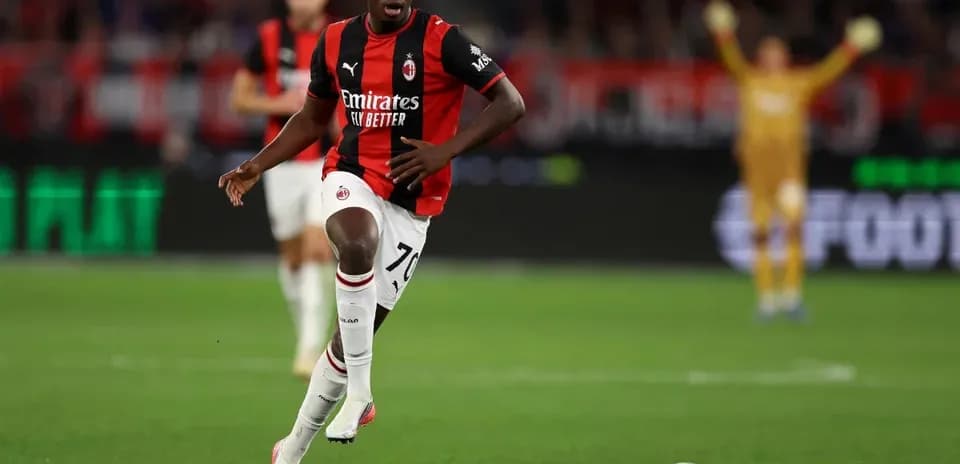 Jugador de AC Milan corriendo con el balón en campo