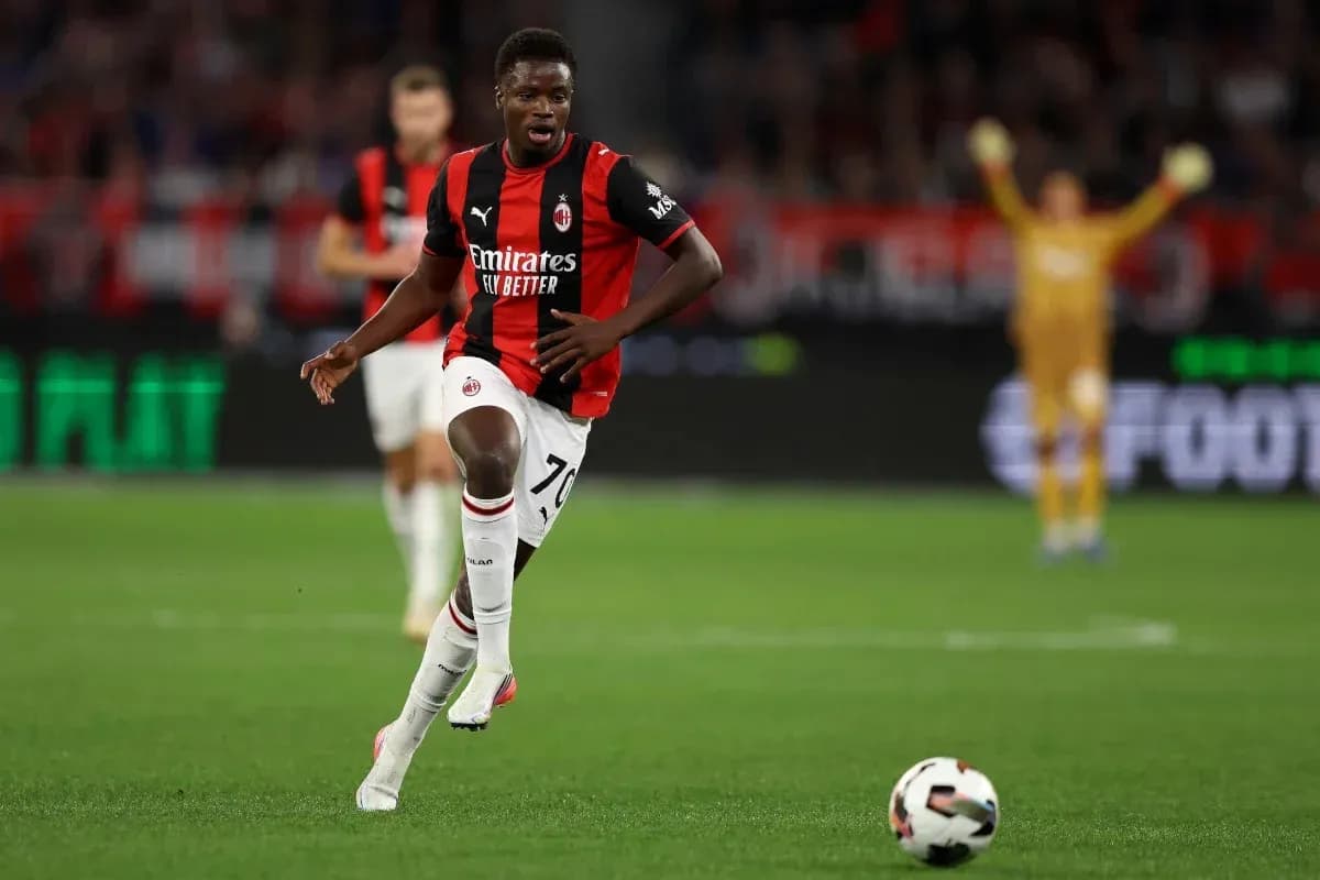 Jugador de AC Milan corriendo con el balón en campo