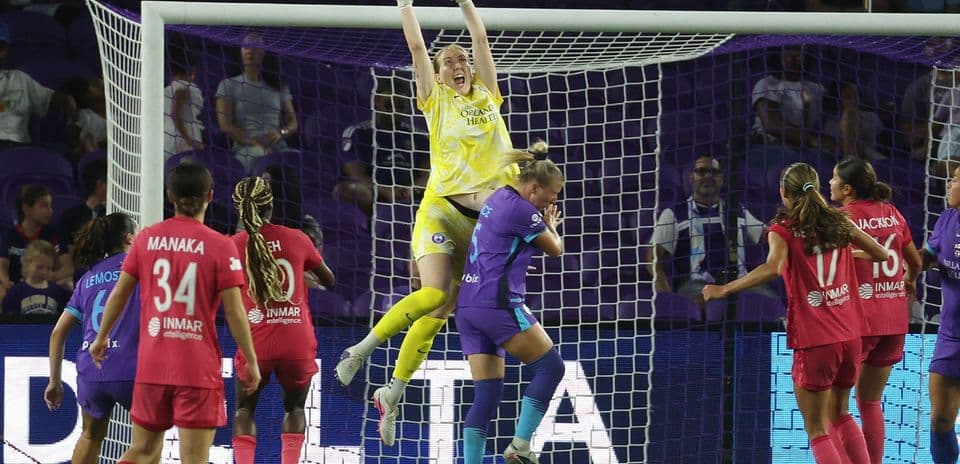 Portera atrapando el balón en un partido