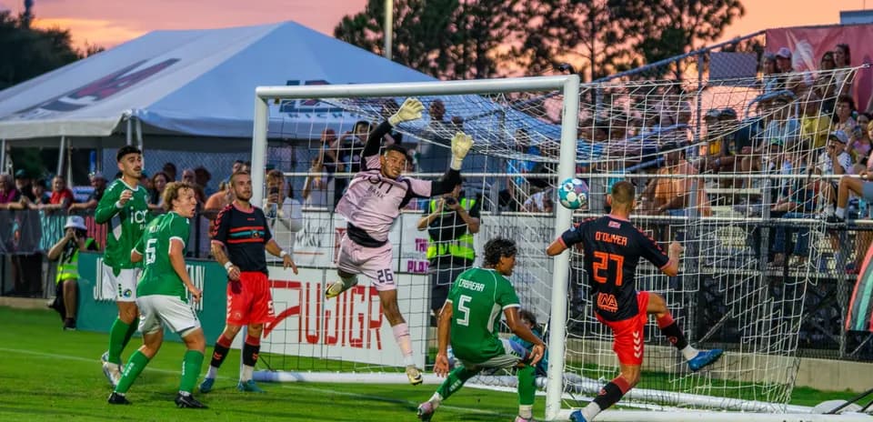 Portero saltando para detener un tiro a gol