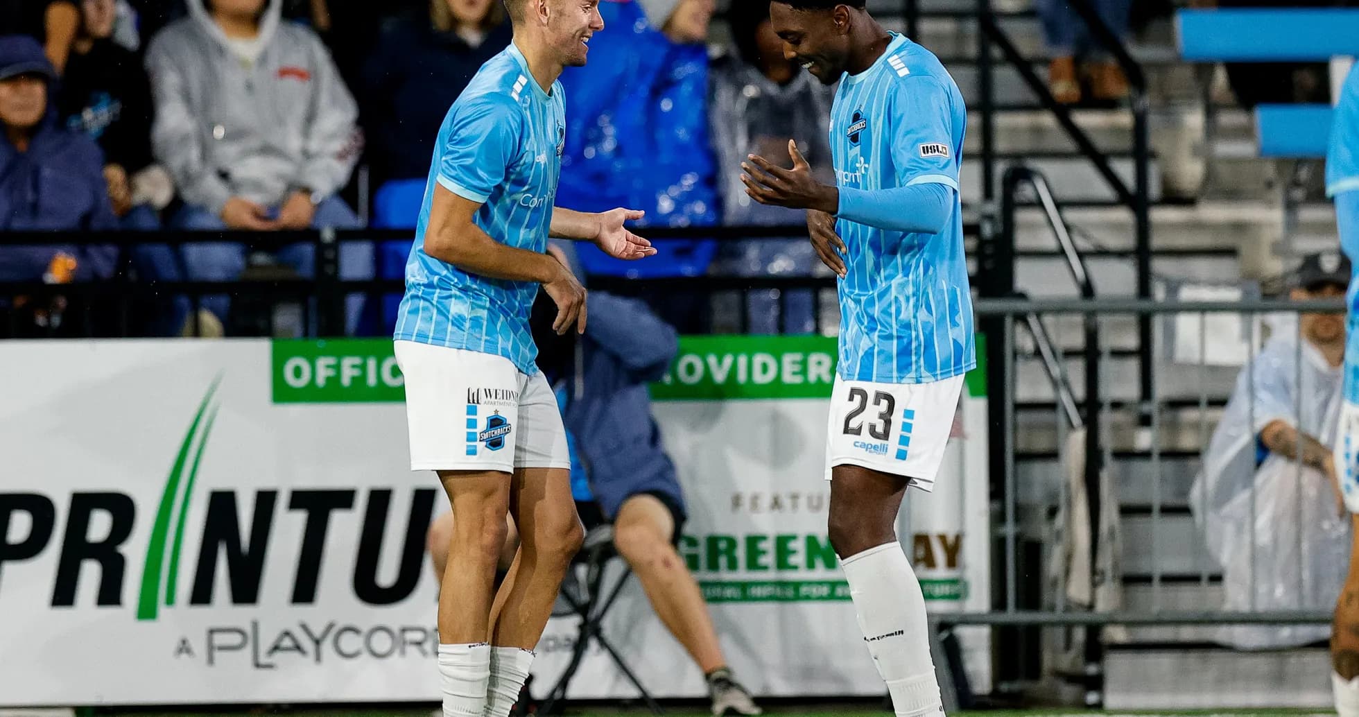 Dos jugadores celebrando en el campo de fútbol