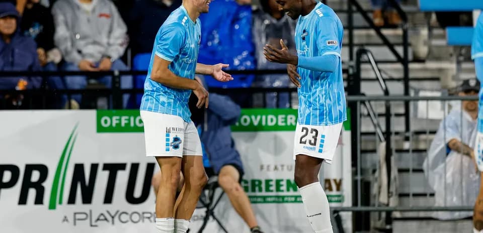 Dos jugadores celebrando en el campo de fútbol