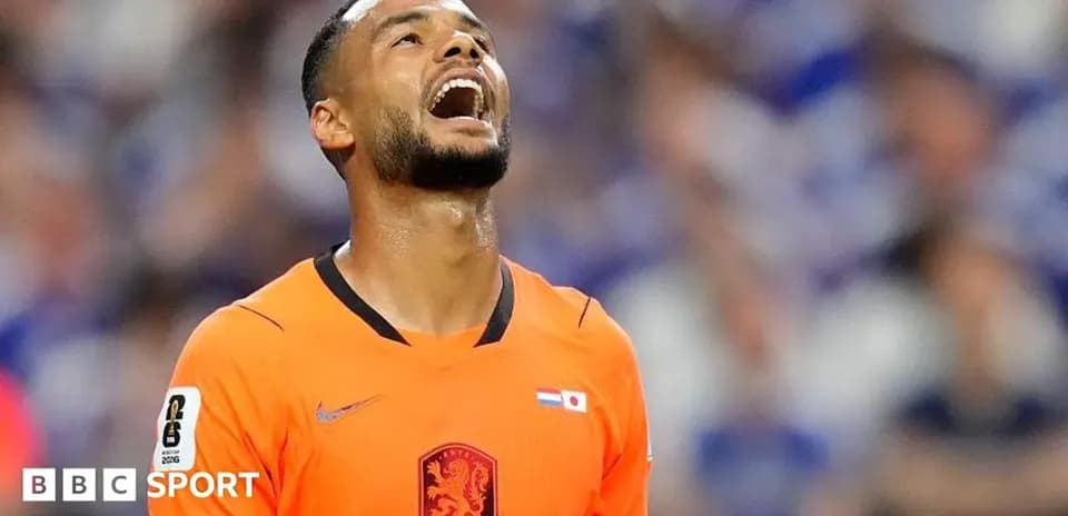 Jugador con camiseta naranja mirando hacia arriba en el campo