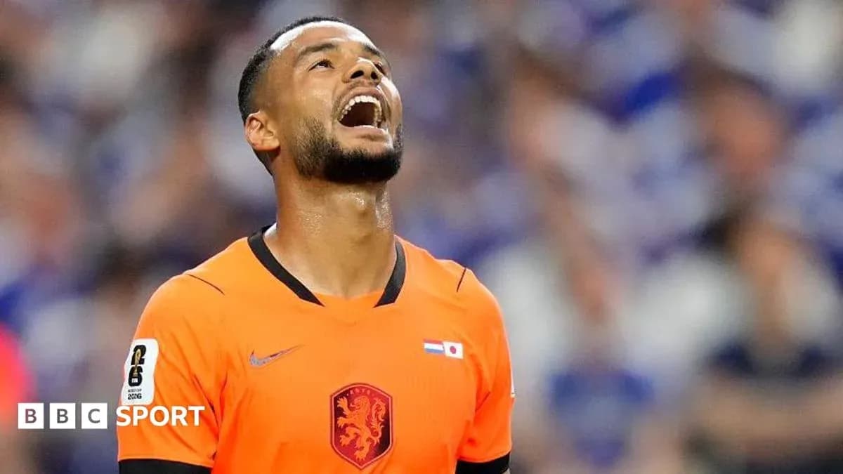 Jugador con camiseta naranja mirando hacia arriba en el campo