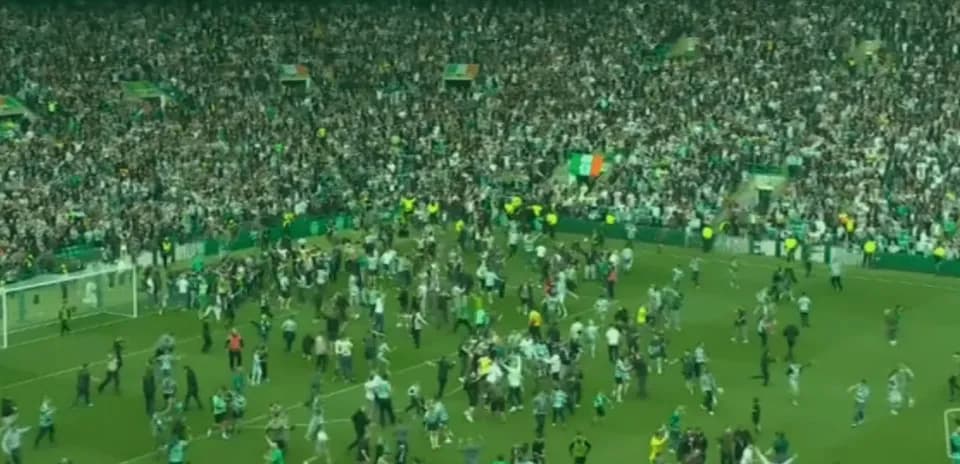 Aficionados celebrando en el campo de fútbol