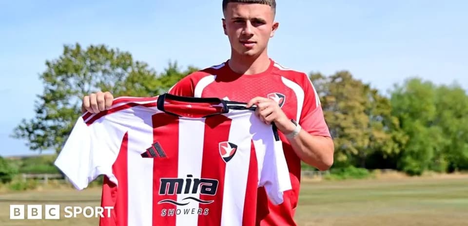 Jugador sosteniendo camiseta de Cheltenham Town en entrenamiento