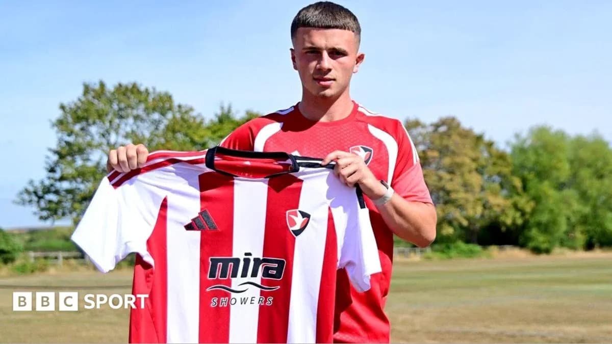 Jugador sosteniendo camiseta de Cheltenham Town en entrenamiento