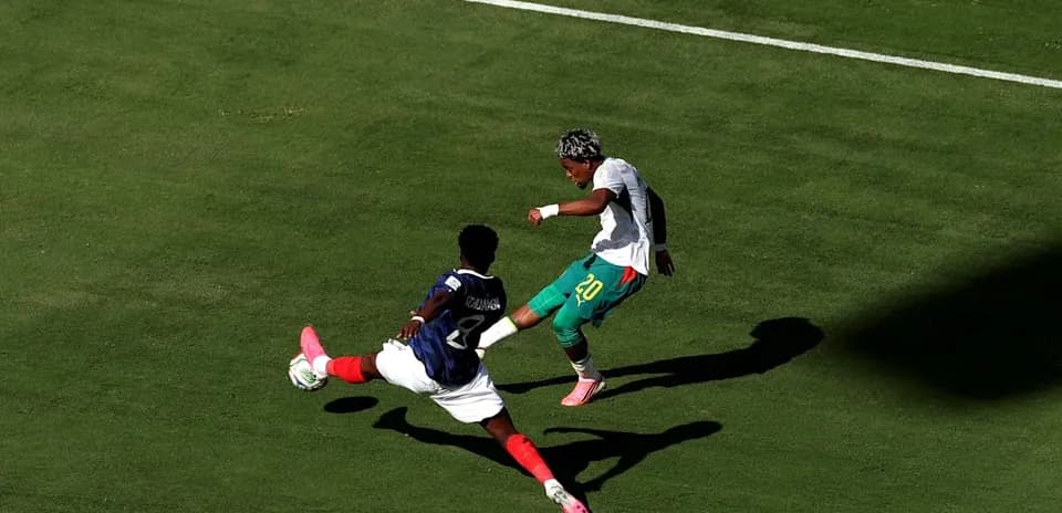 Jugador esquivando a oponente durante un partido de fútbol