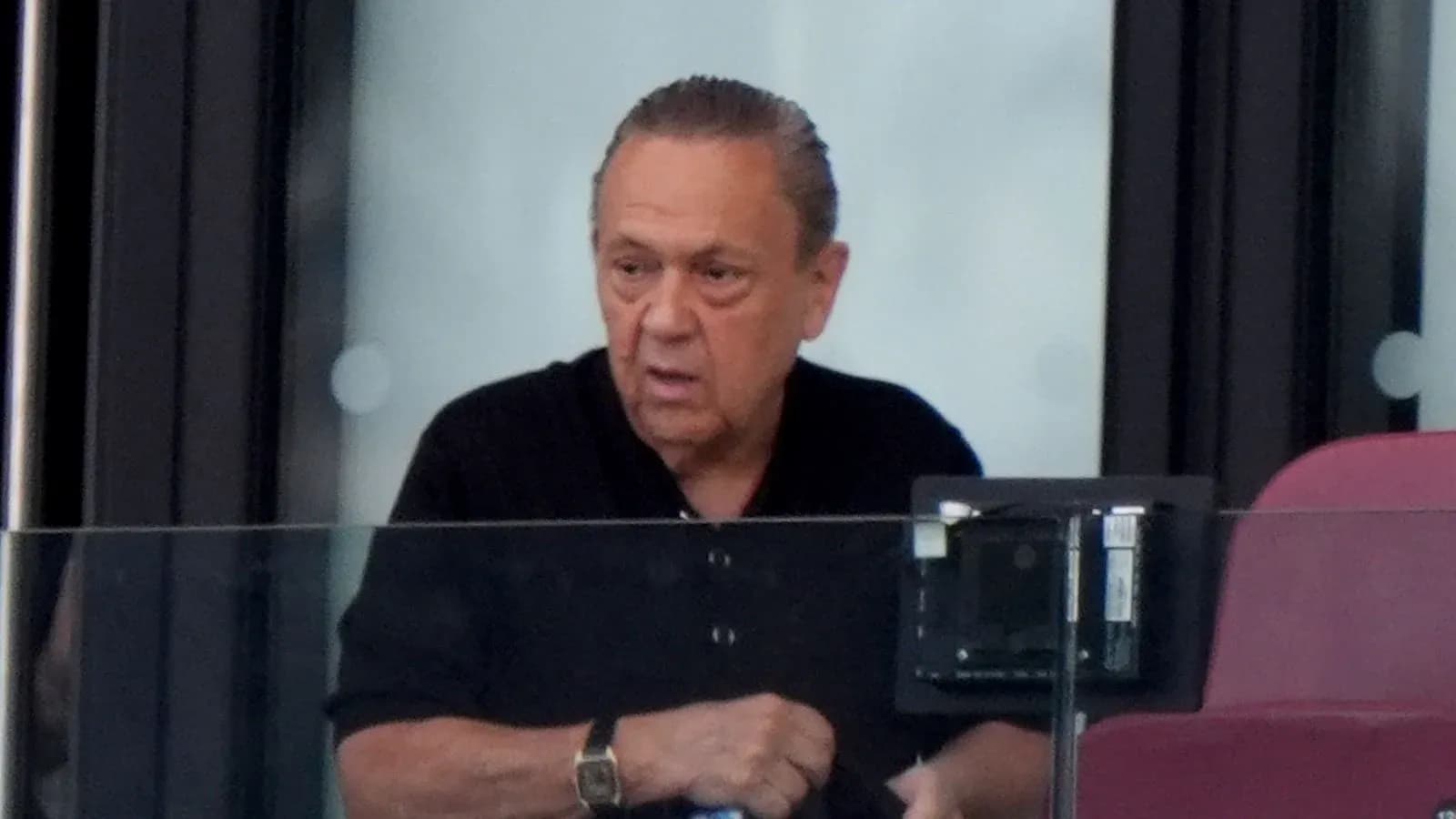 Hombre en un palco de estadio observando el juego