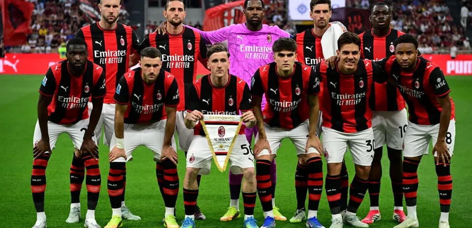 Equipo de AC Milan posando con un banderín