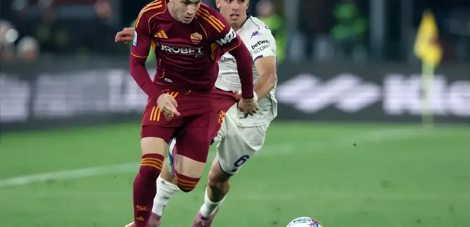 Jugador de Roma llevando el balón mientras es perseguido