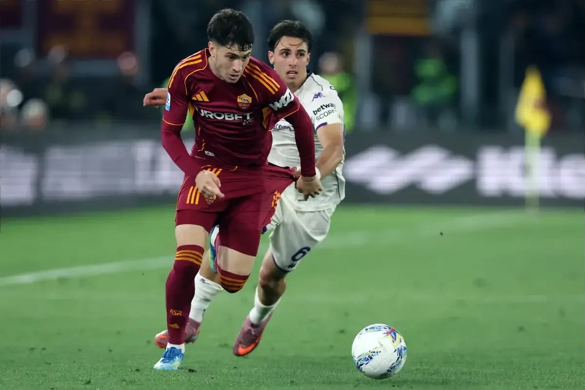 Jugador de Roma llevando el balón mientras es perseguido