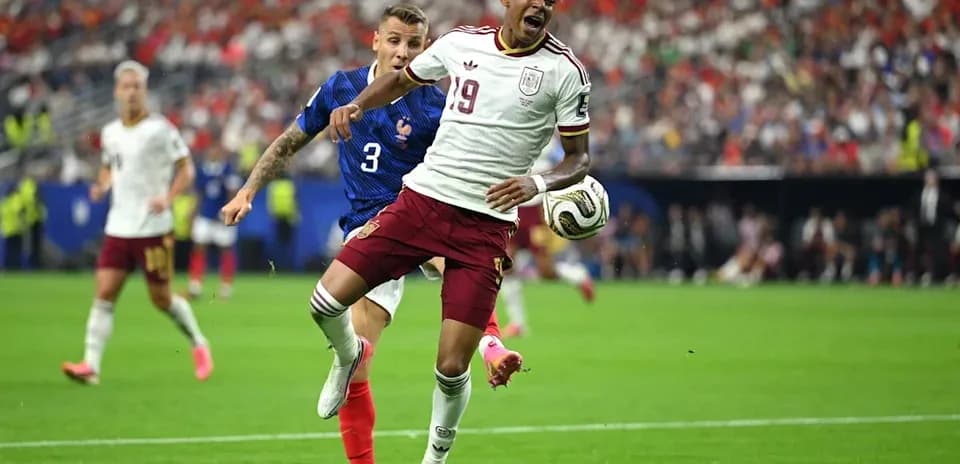 Jugador español siendo derribado por defensa francés