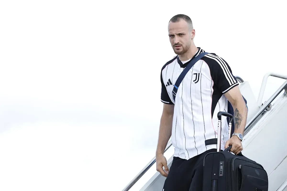 Jugador de Juventus bajando del avión con maleta