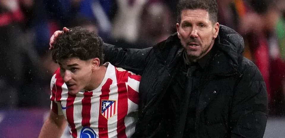 Entrenador de Atlético ayudando a jugador en el campo