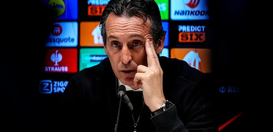 Entrenador en conferencia de prensa señalando su cabeza