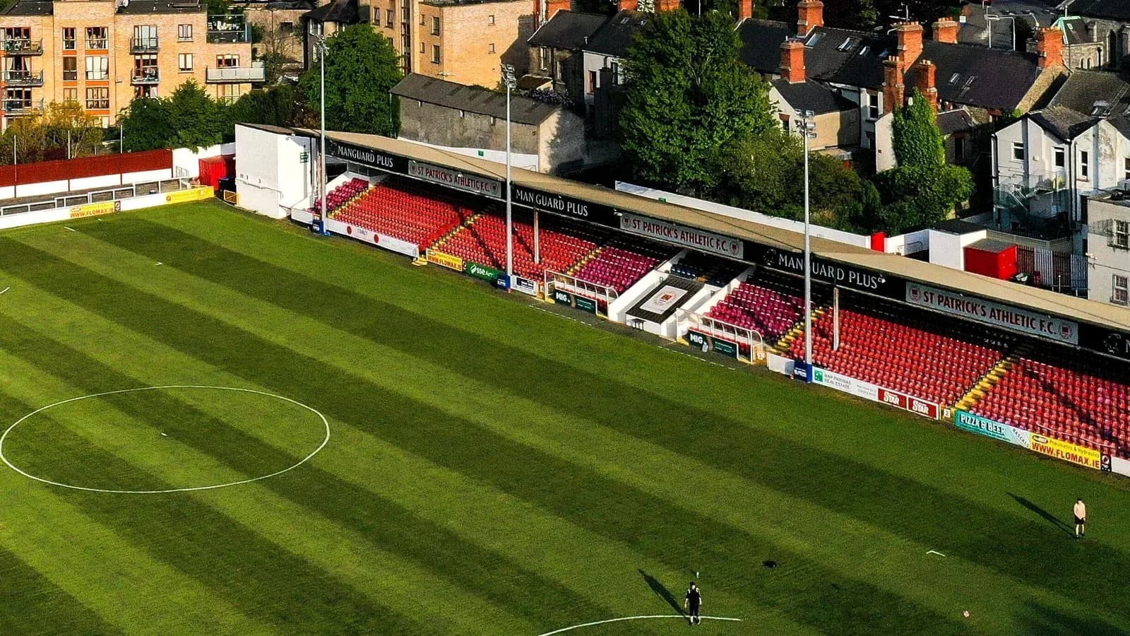 Campo de fútbol con gradas vacías y césped verde