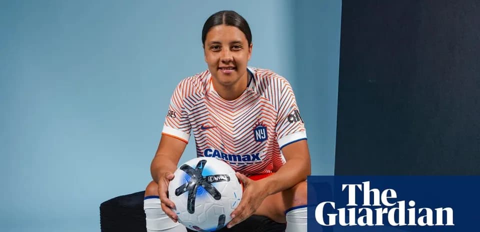 Jugadora de fútbol sosteniendo balón en estudio